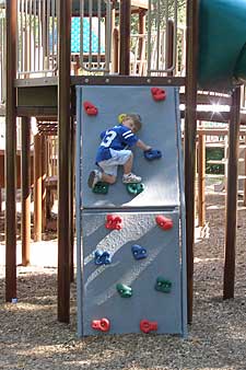 Child on playground climbing wall